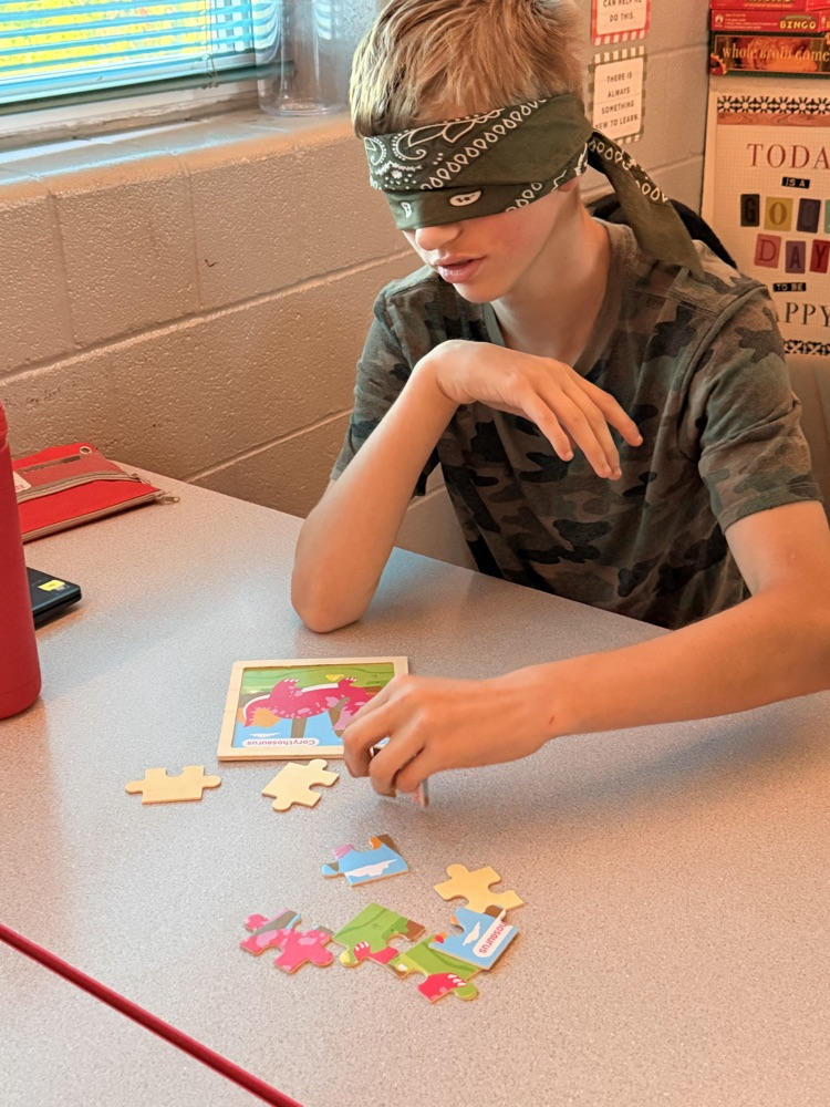student putting together a puzzle while blindfolded