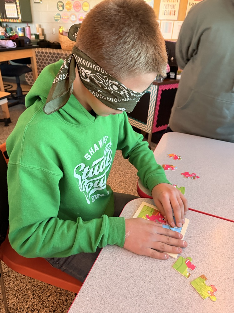 student putting together a puzzle while blindfolded