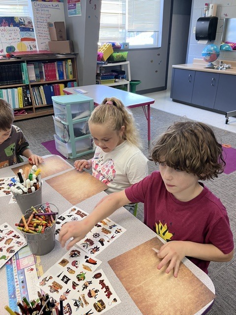 Two young students creating a treasure map.