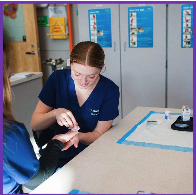 This is an image of student holding someone hand and working on something medical 