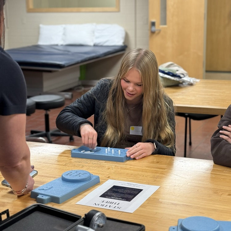 Olivia F tests her fine motor skills during the OT session