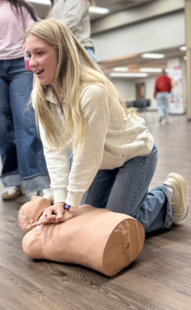A student practices their CPR compressions.