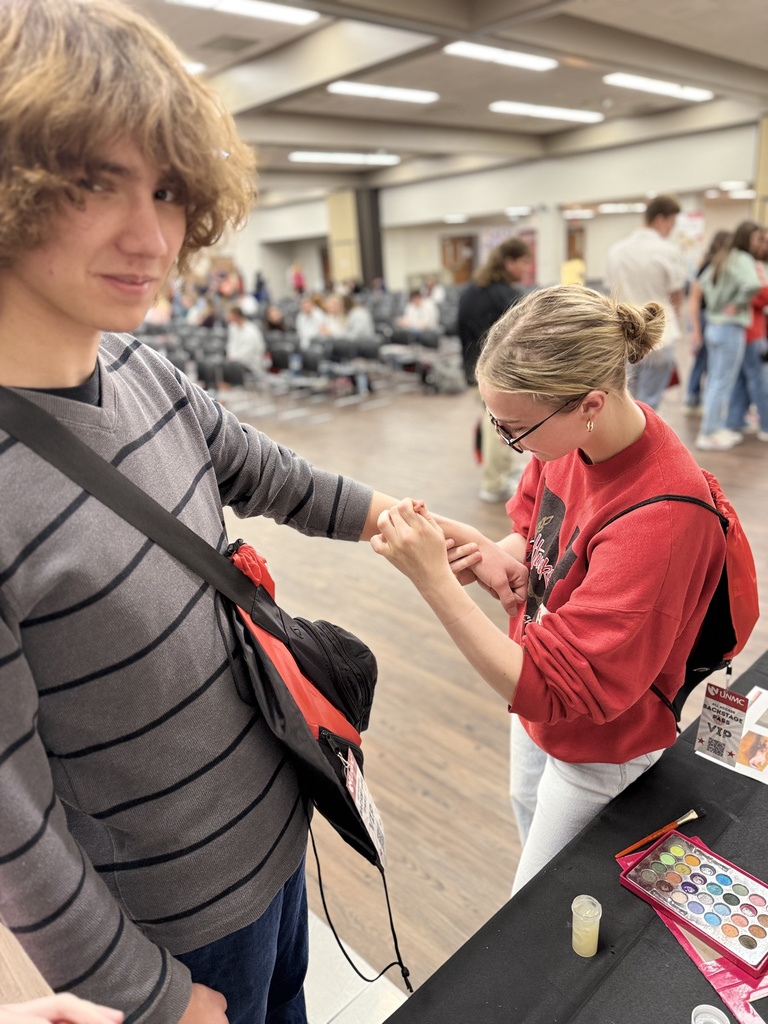 Two students learn about hematomas at the nursing booth.