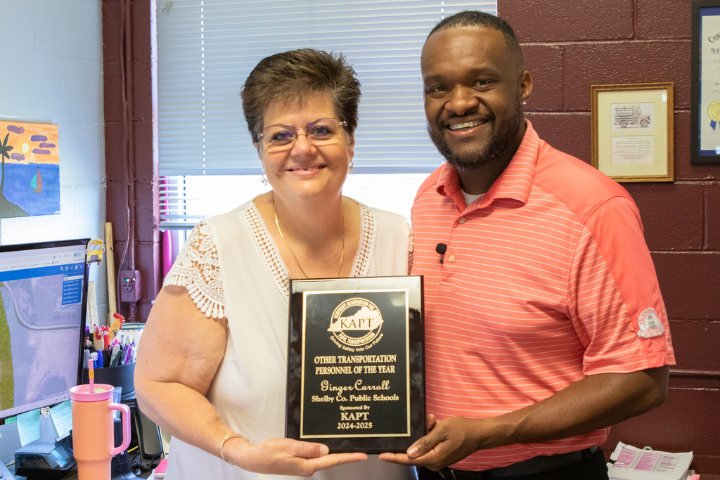a photo of Ginger Carroll and Mannie Stone posing with Ginger's KAPT award.