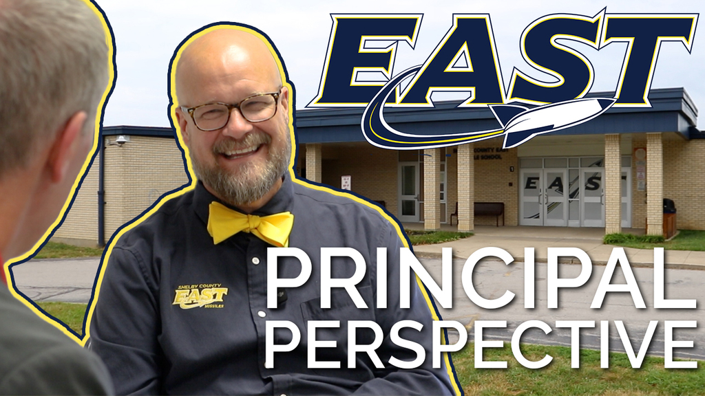a video thumbnail of mr ryan allan smiling, photoshopped onto a photo of the east middle school building.