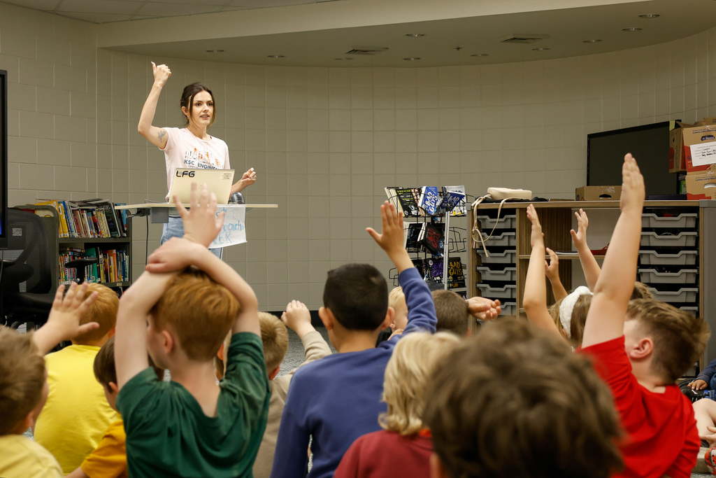 students raising hands to Alora speaking