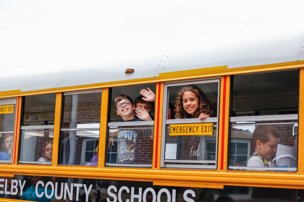 kids and teachers waving goodbye