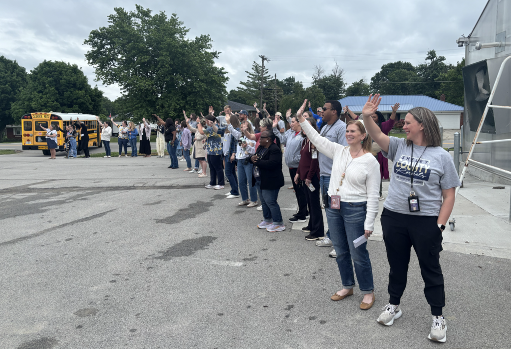 kids and teachers waving goodbye