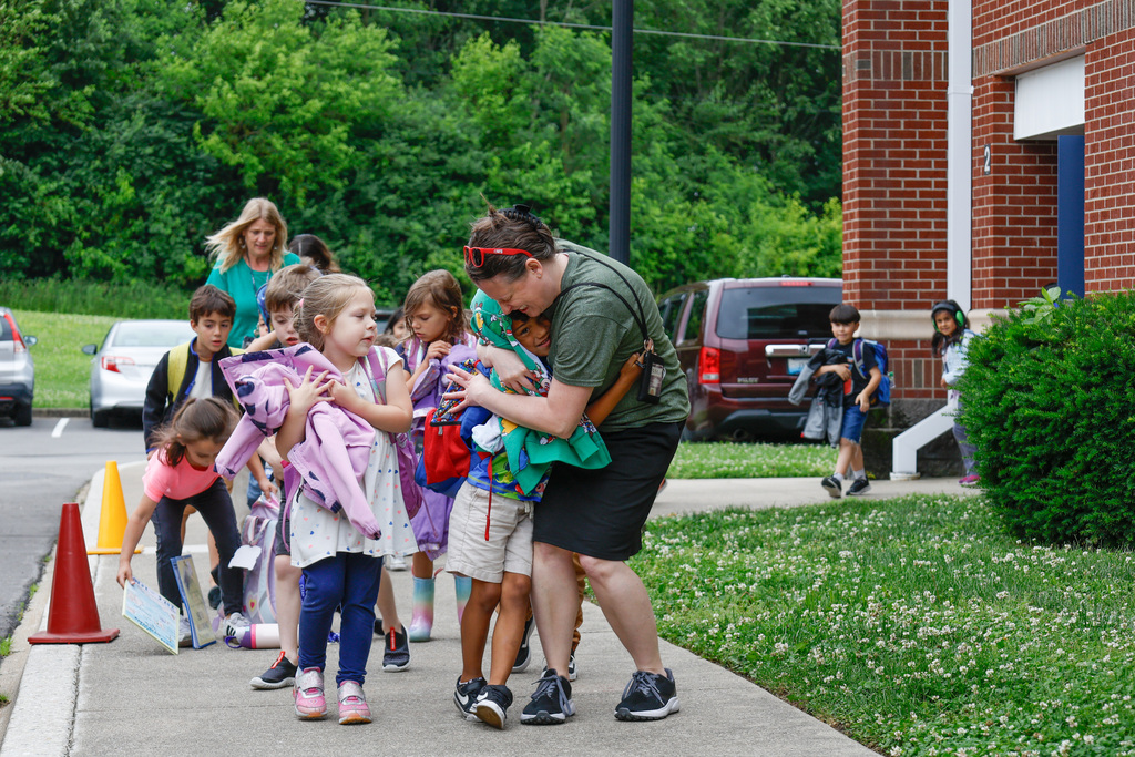 kids and teachers hugging goodbye