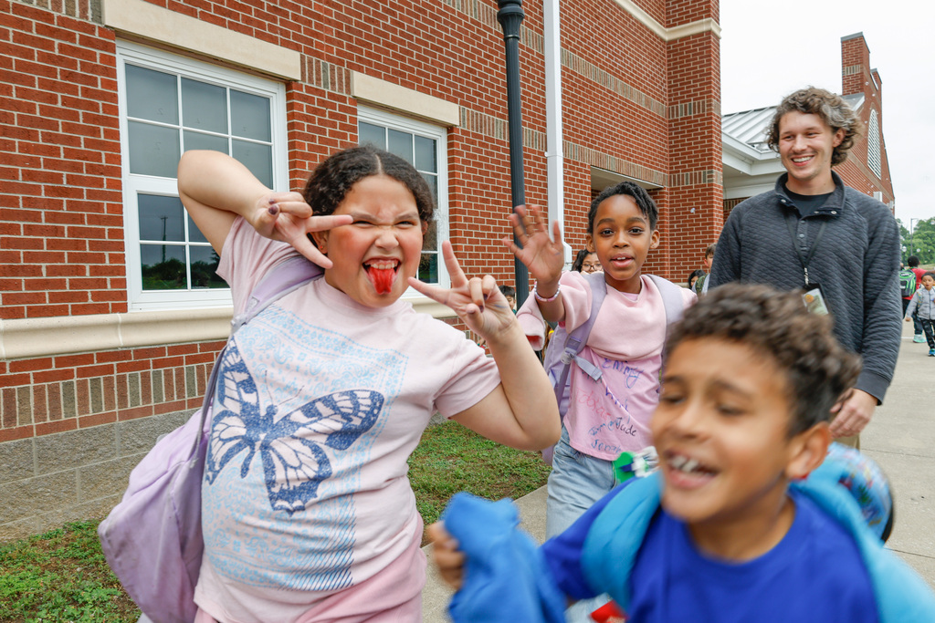 kids and teachers waving goodbye