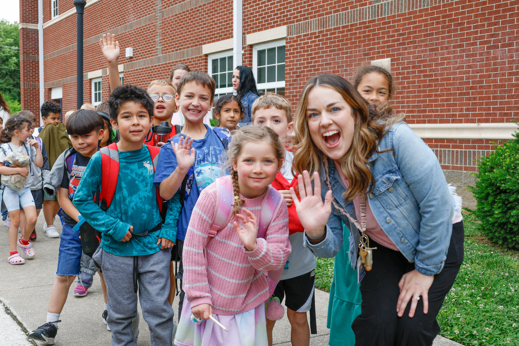 kids and teachers waving goodbye