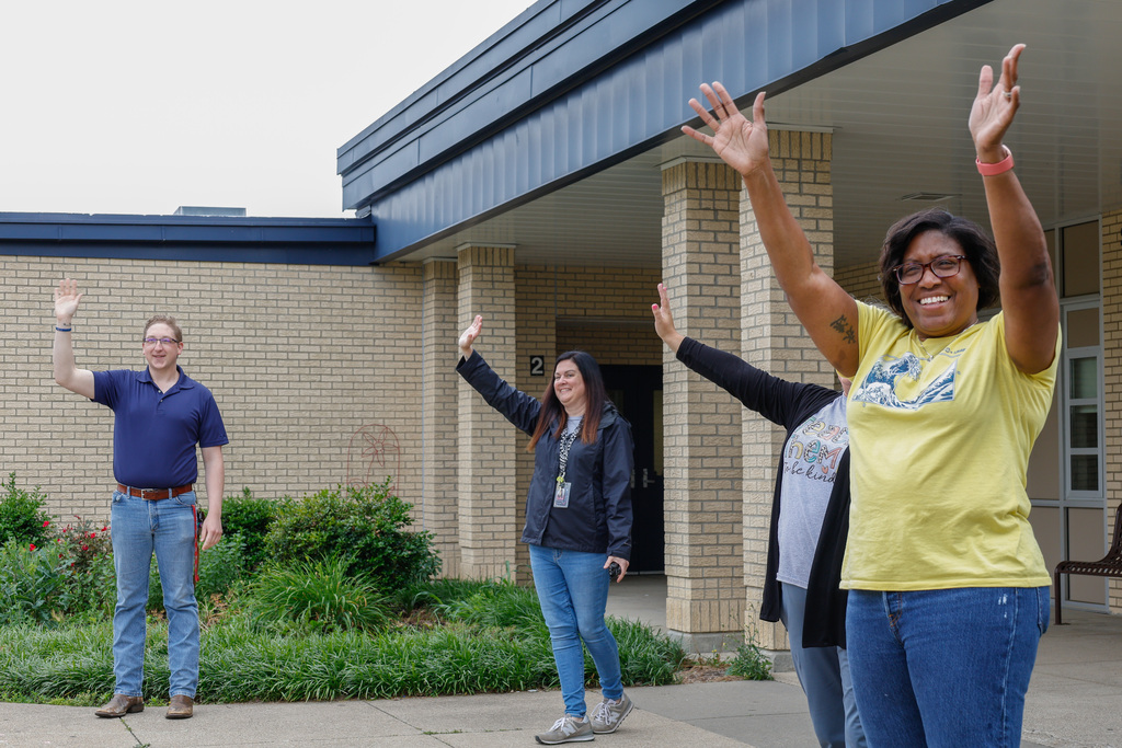 kids and teachers waving goodbye