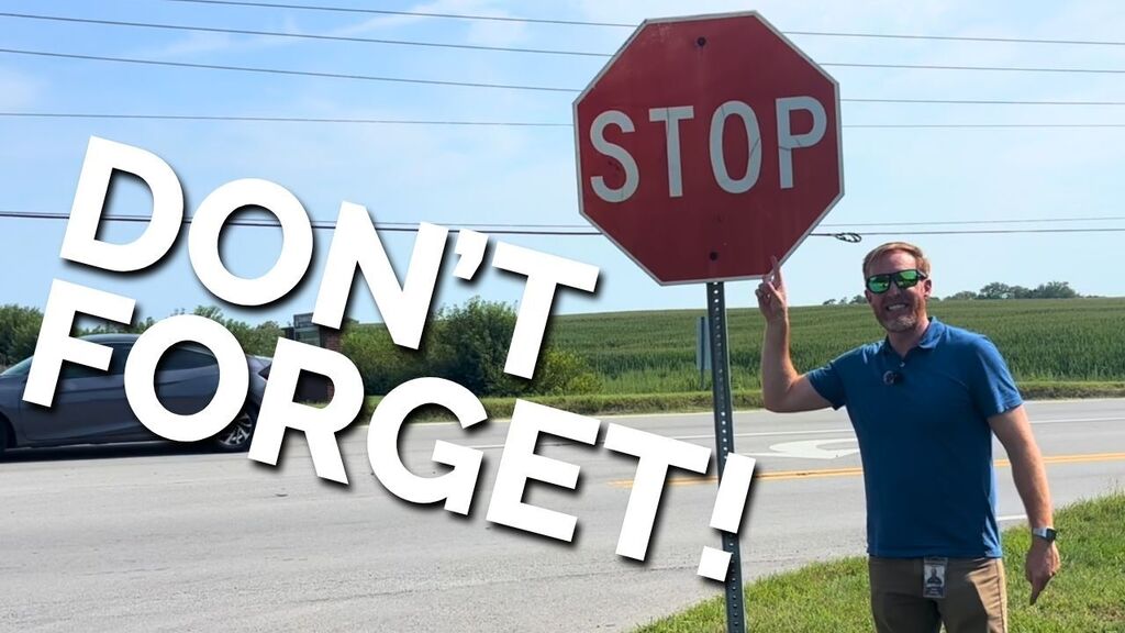 Director of Transportation Nate Jebsen standing in front of and pointing at a stop sign.