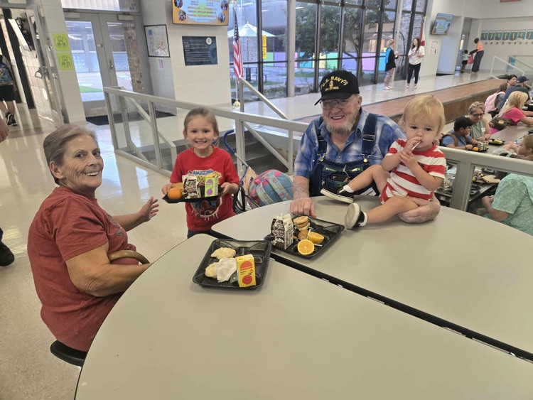 student eating breakfast with grandparents 