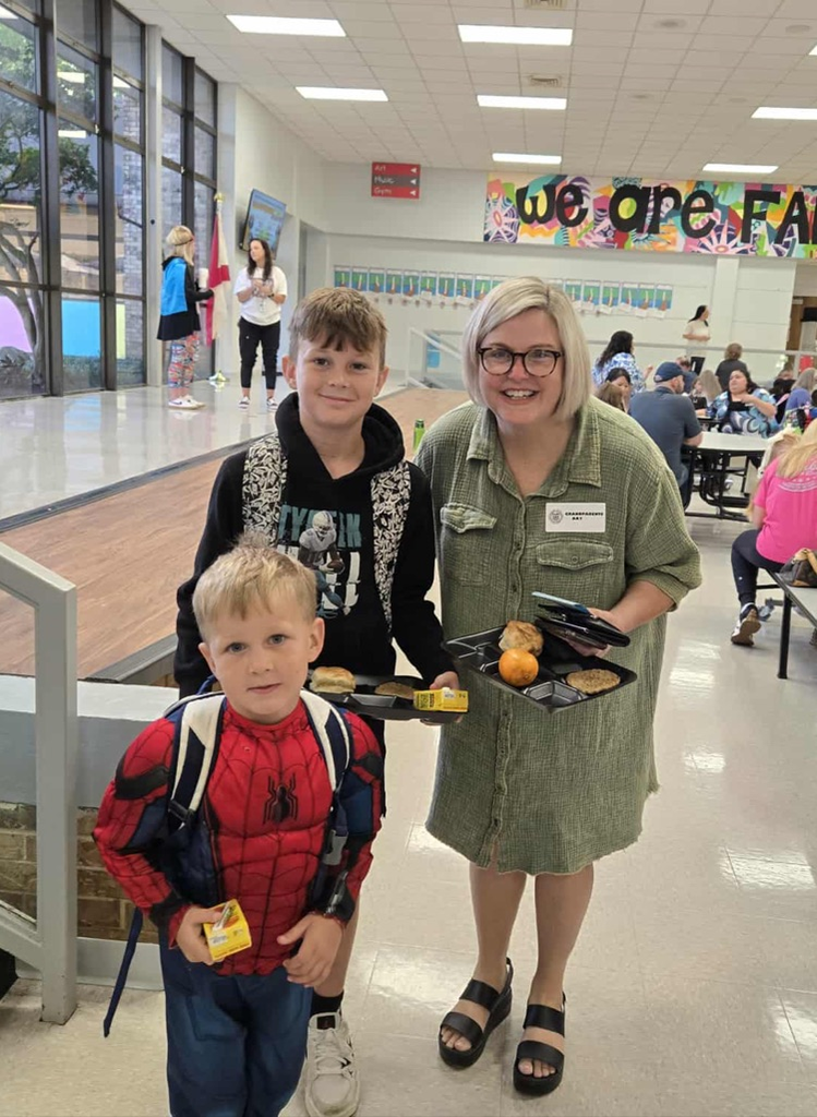 students standing with grandparent at breakfast 