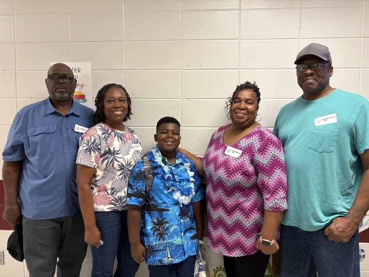 grandson posing for a picture with grandparents   