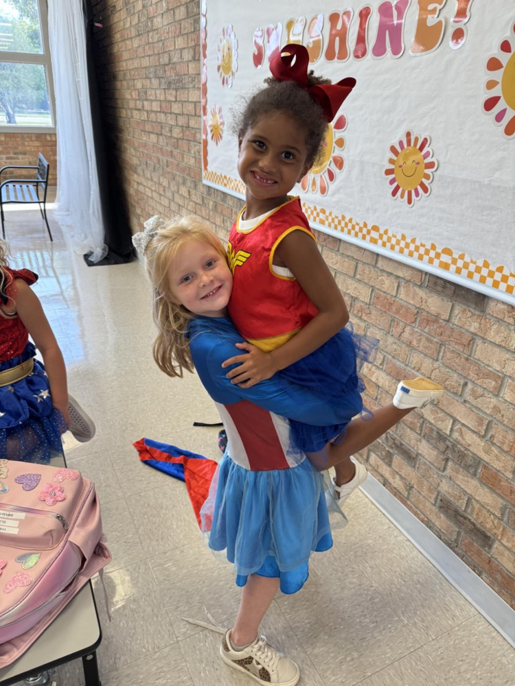 girl picking up a friend dressed as Wonder Woman 