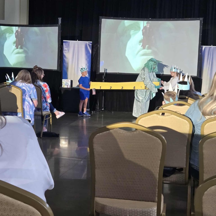 Libby Liberty uses a measure tape to show students the statue’s size