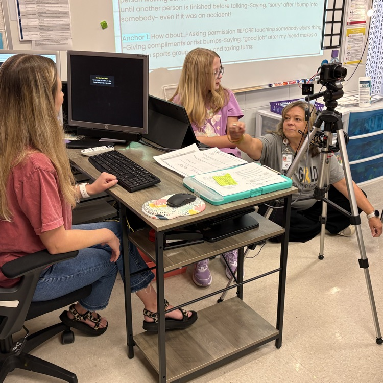 teacher assisting student with technology during broadcast