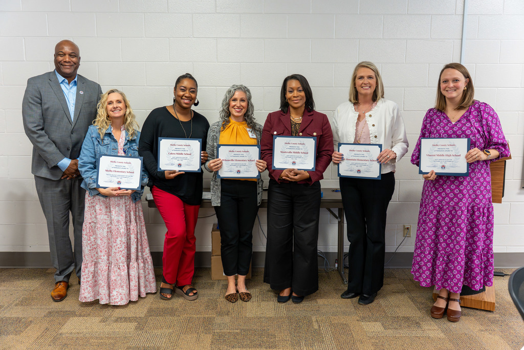 Administrators are recognized for attendance achievements.