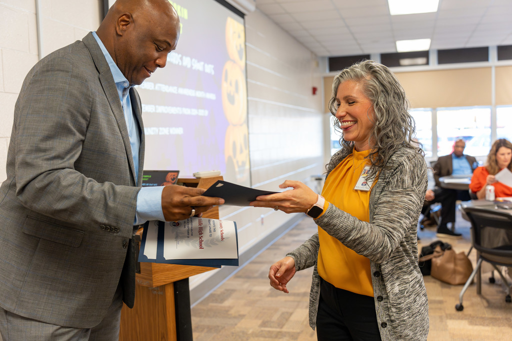 Administrators are recognized for attendance achievements.