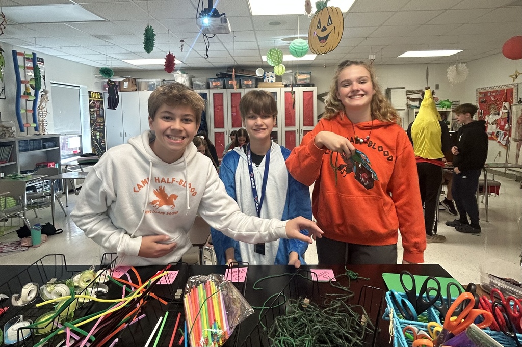 7th grade science students enjoying their Halloween activity with supplies in front of them
