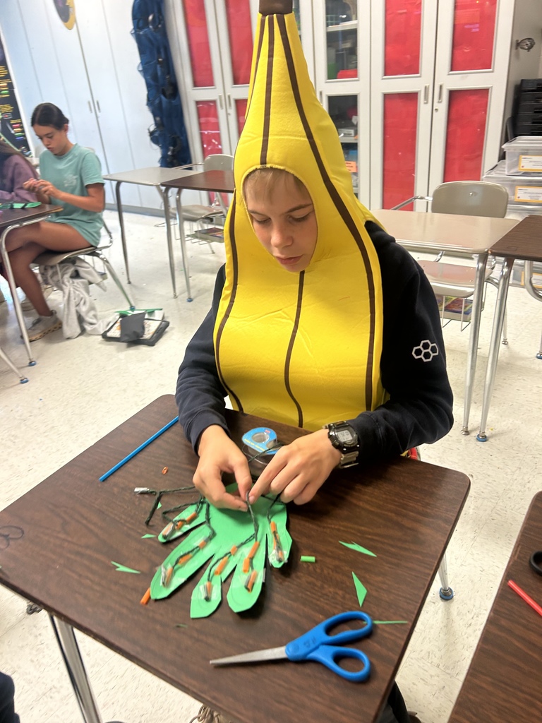 7th grade science students enjoying their Halloween activity with supplies in front of them