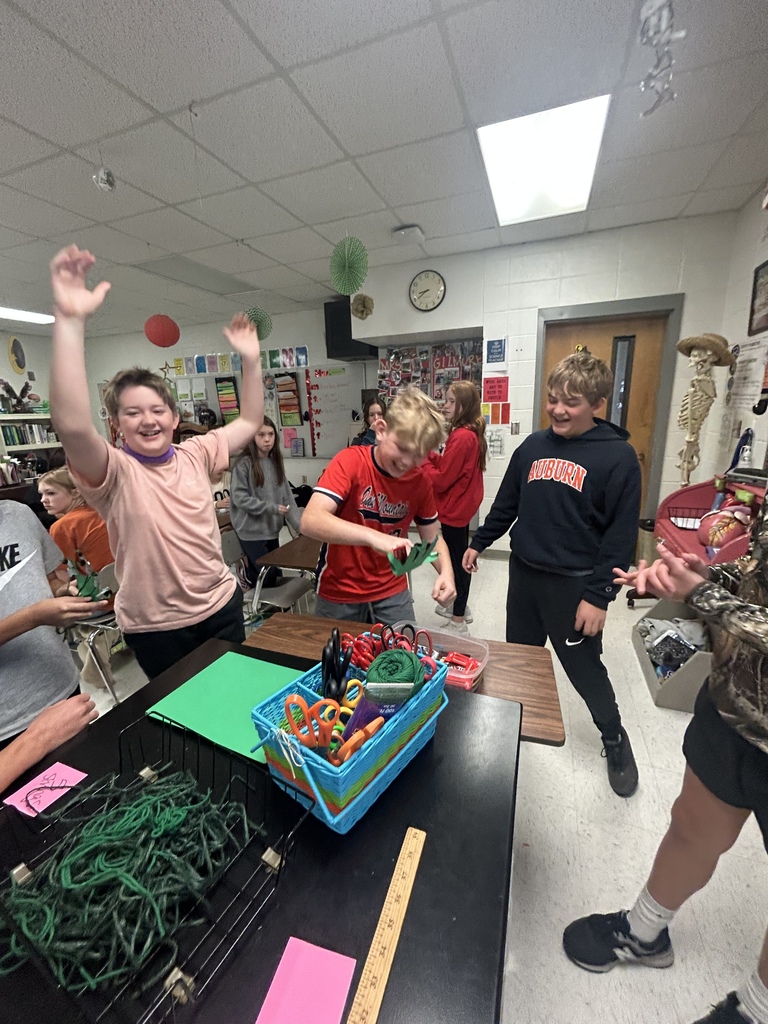 7th grade science students enjoying their Halloween activity with supplies in front of them