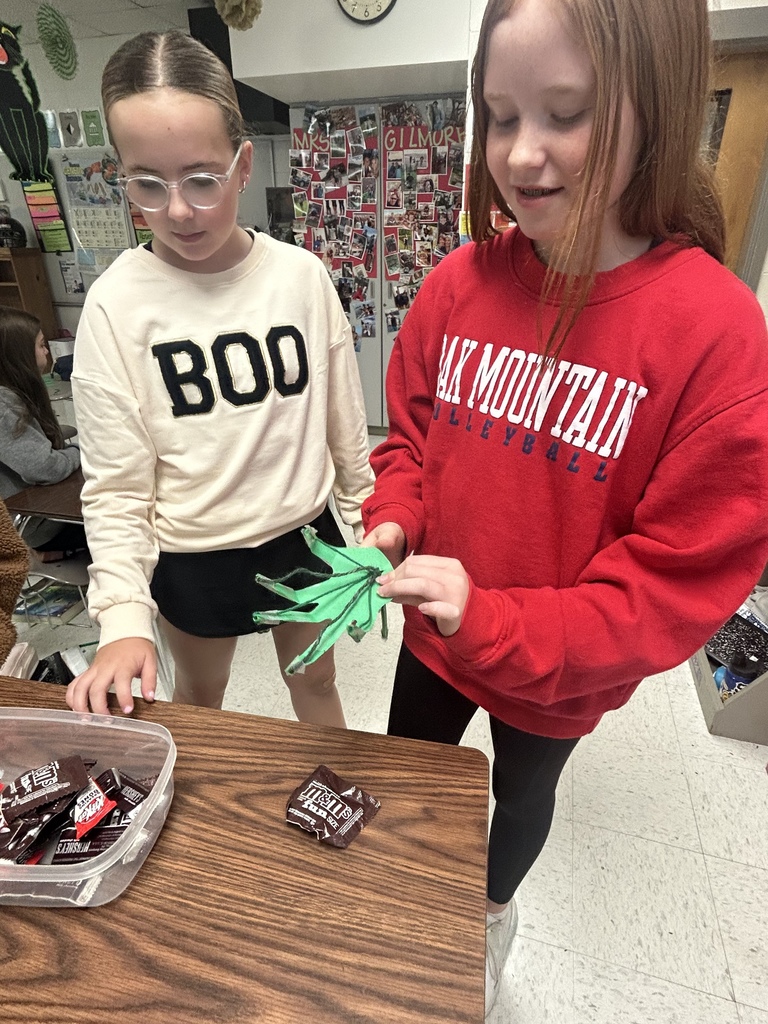 7th grade science students enjoying their Halloween activity with supplies in front of them