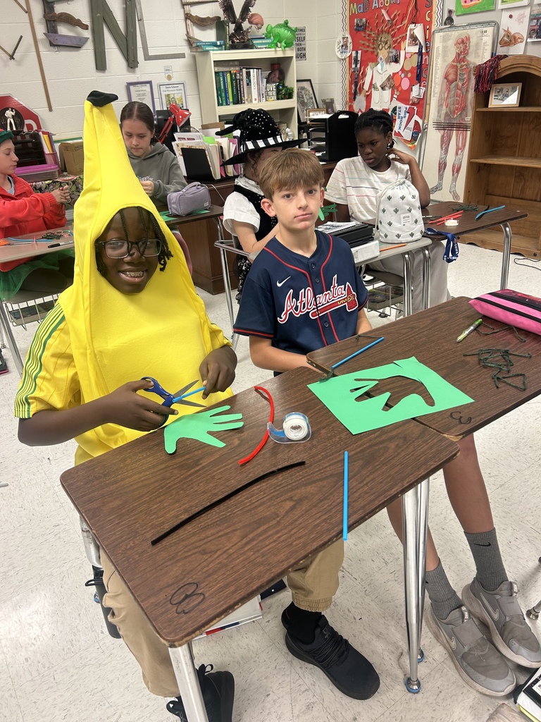 7th grade science students enjoying their Halloween activity with supplies in front of them