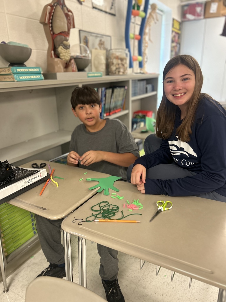 7th grade science students enjoying their Halloween activity with supplies in front of them