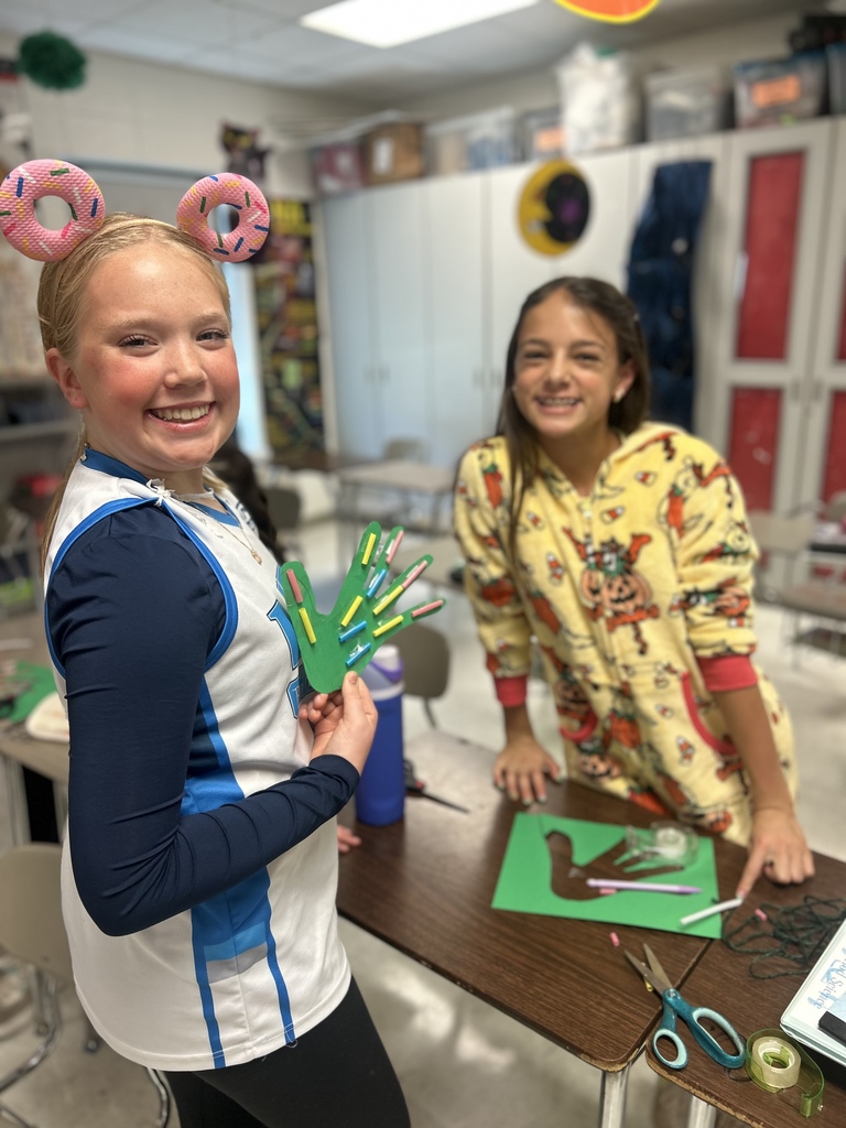 7th grade science students enjoying their Halloween activity with supplies in front of them