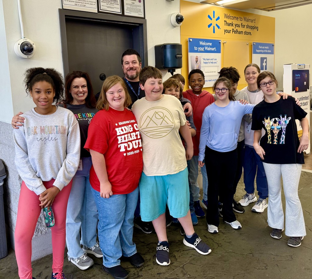 Students from Ms. Stewart's class standing with the WalMart manager with big smiles!