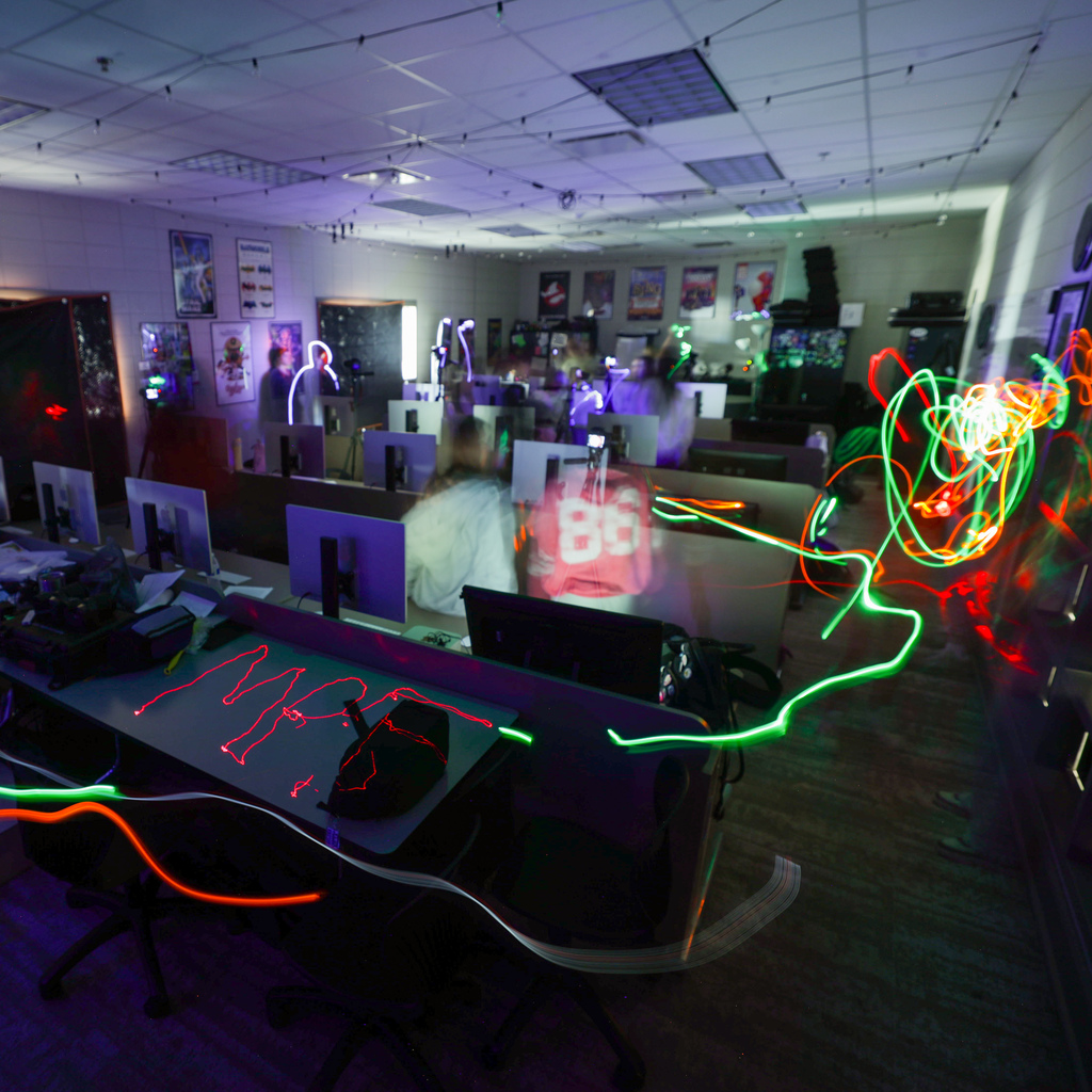Students in a classroom using small lights to "paint" onto camera sensors