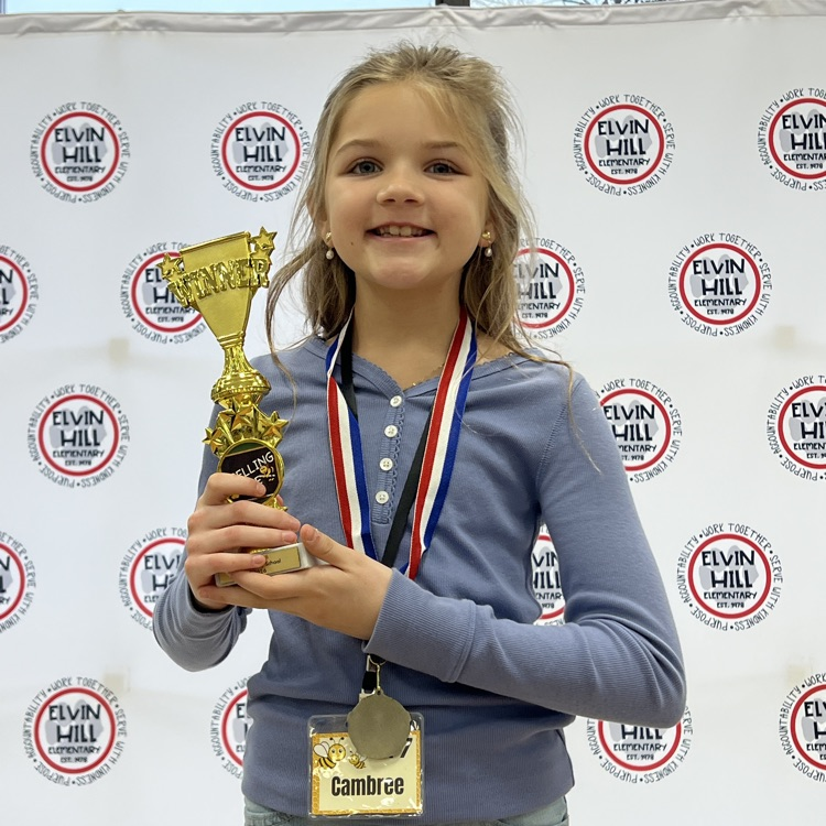 spelling bee winner holding the trophy 