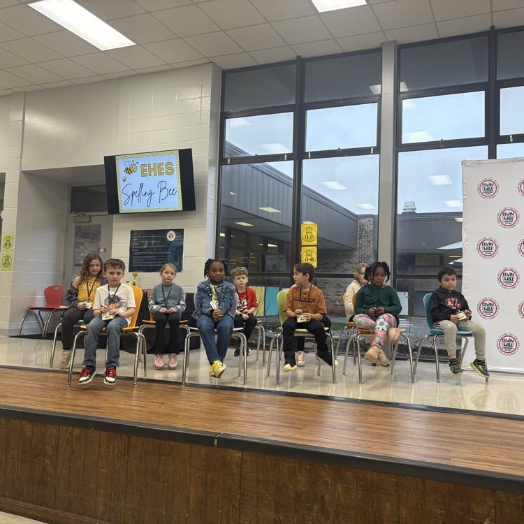 spelling bee participants sitting on the stage 
