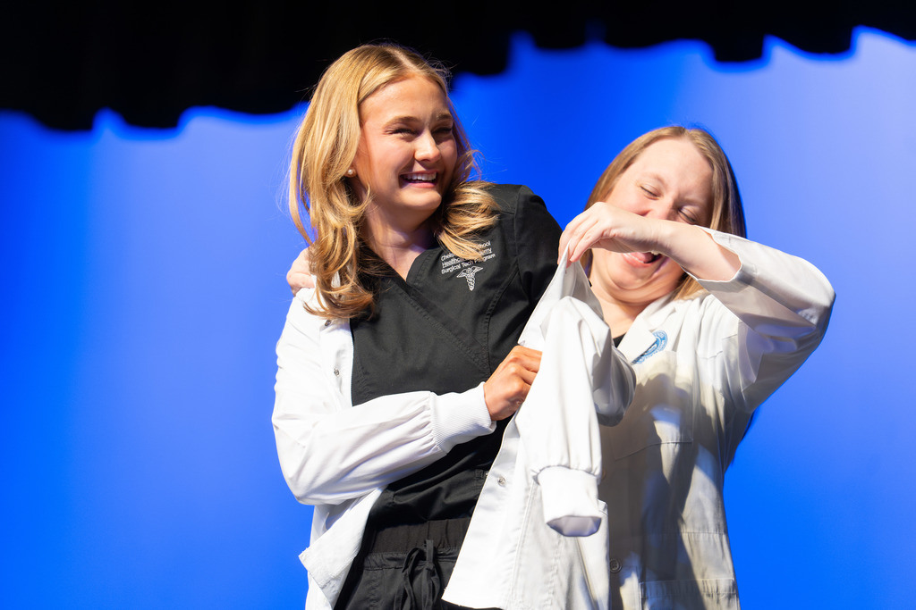 Student receives a white jacket during the ceremony.