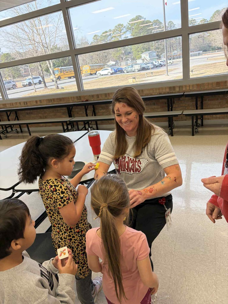 students apply temporary tattoos on administrators 