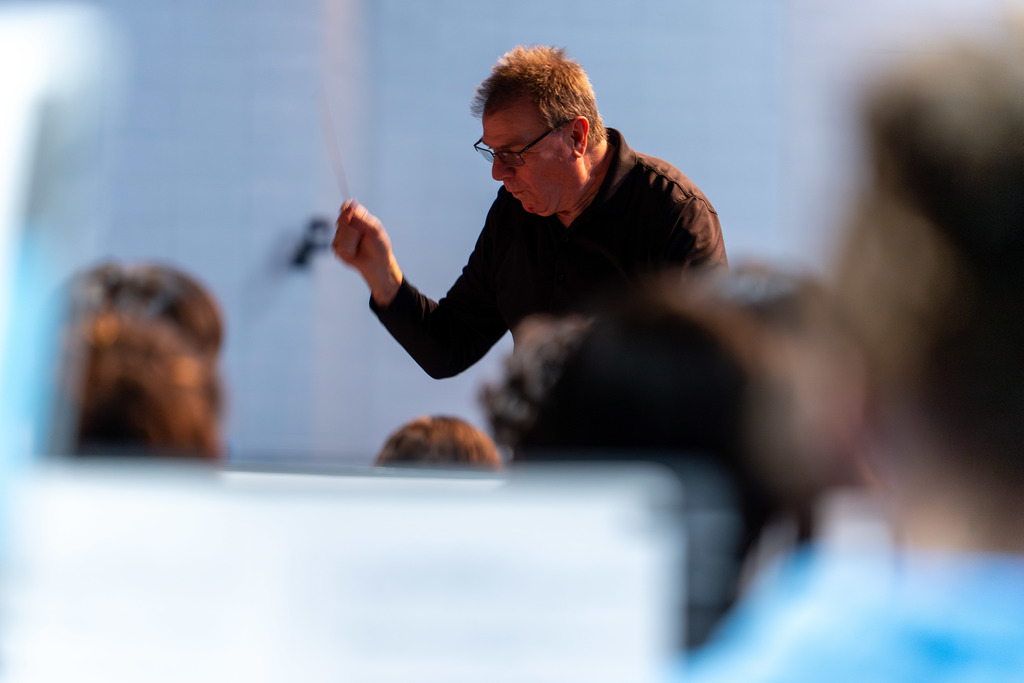 A director leads students in music.