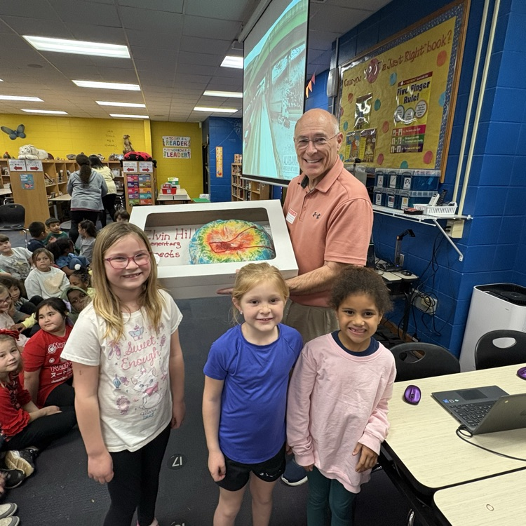 James Spann with king cake designed like a radar, students pose in front
