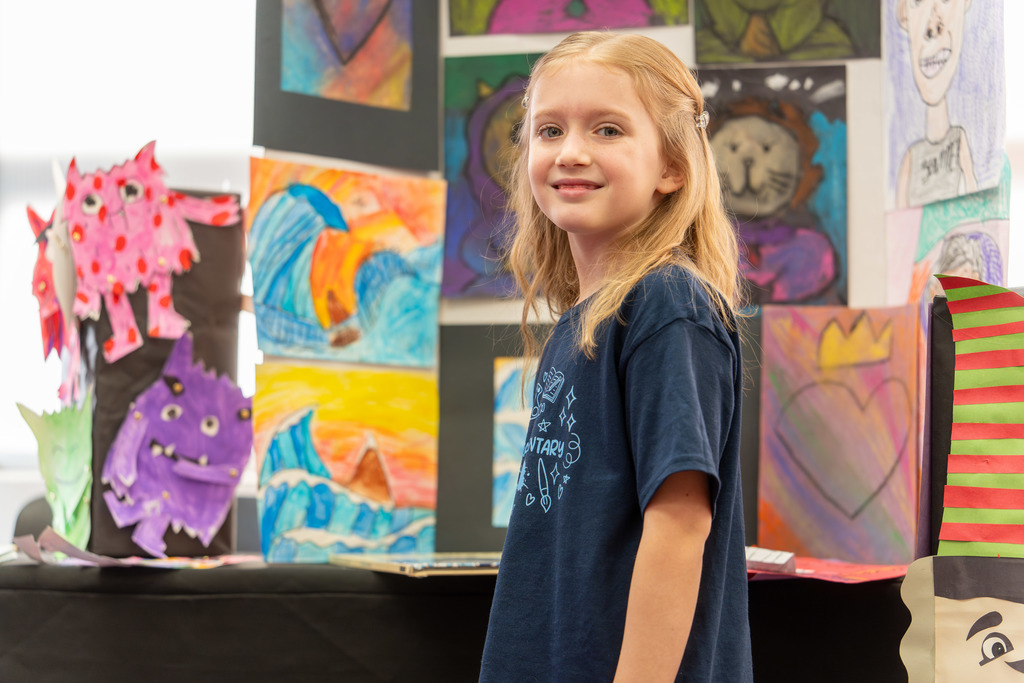 Student poses in front of her display.