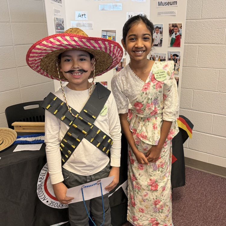 students pose for wax museum for cultural fair demonstration 
