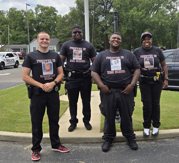 team of school resource officers stand in front of the mailbox and flagpole