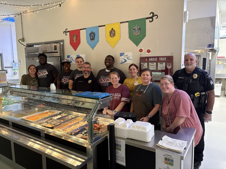 School resource officers pictured with school nutrition staff as they serve Thanksgiving meal