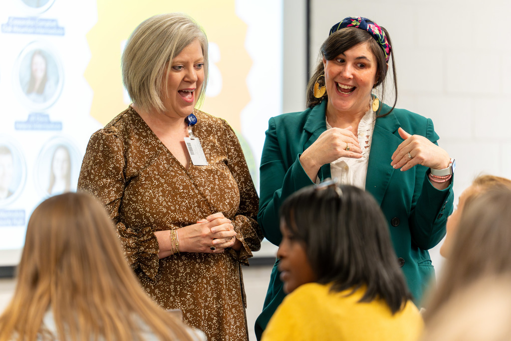 Leaders speak with teachers at the conference.