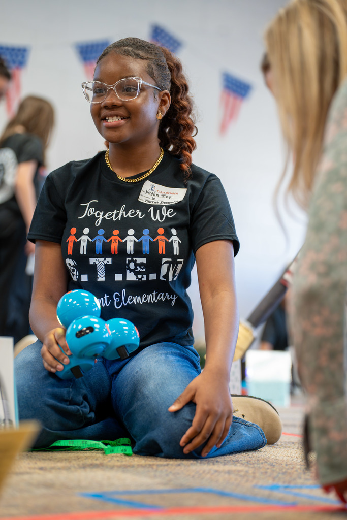 Student smiles with their Dash robot