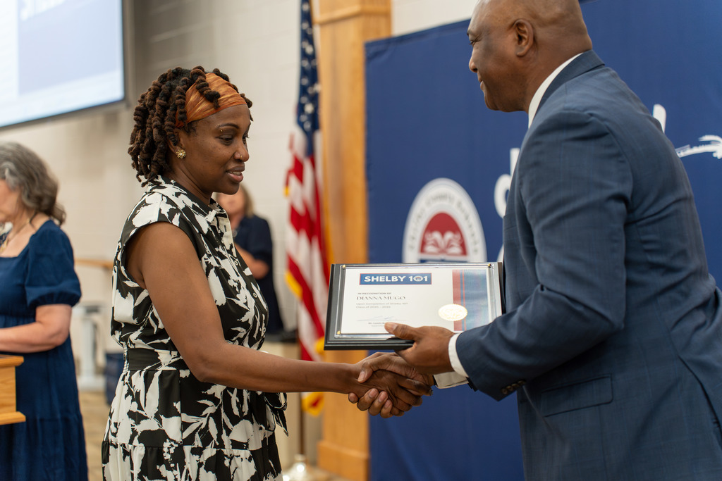 Diana Mugo receiving her certificate from Dr. Lewis Brooks 