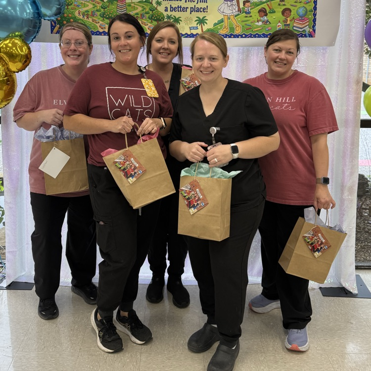 CNP staff poses for a picture with brown gift bags in hand 