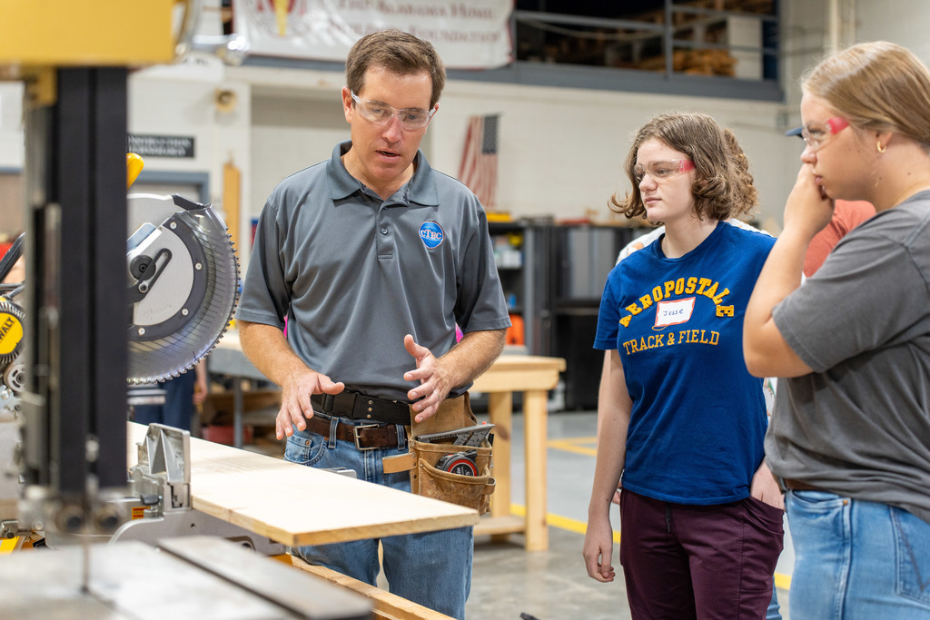 Teacher helping students with construction project 