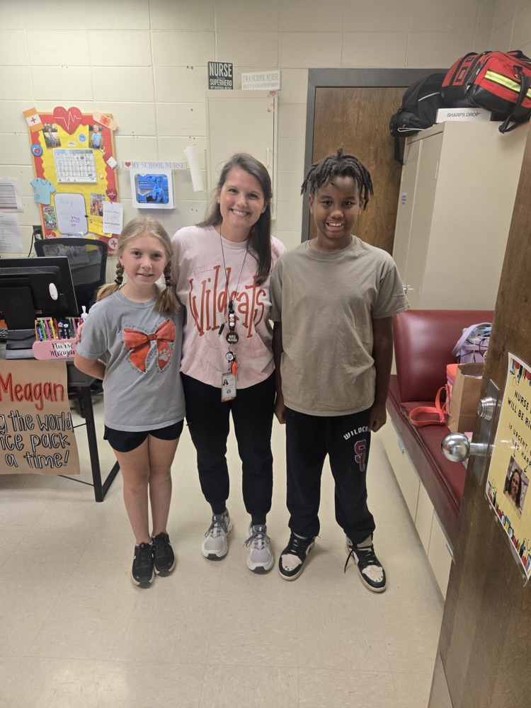 school nurse posed with two students in the health room 